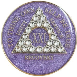 A purple glitter coin with white stones on it.