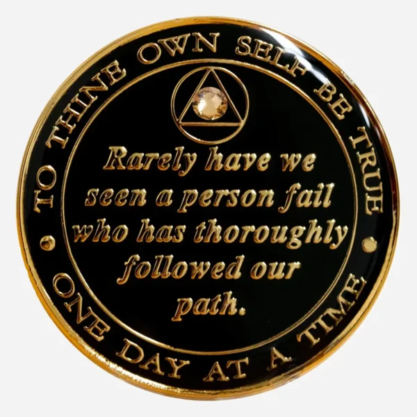The back of a black crystal AA medallion showcasing the hand-painted Serenity Prayer in gold with a gold crystal accent.