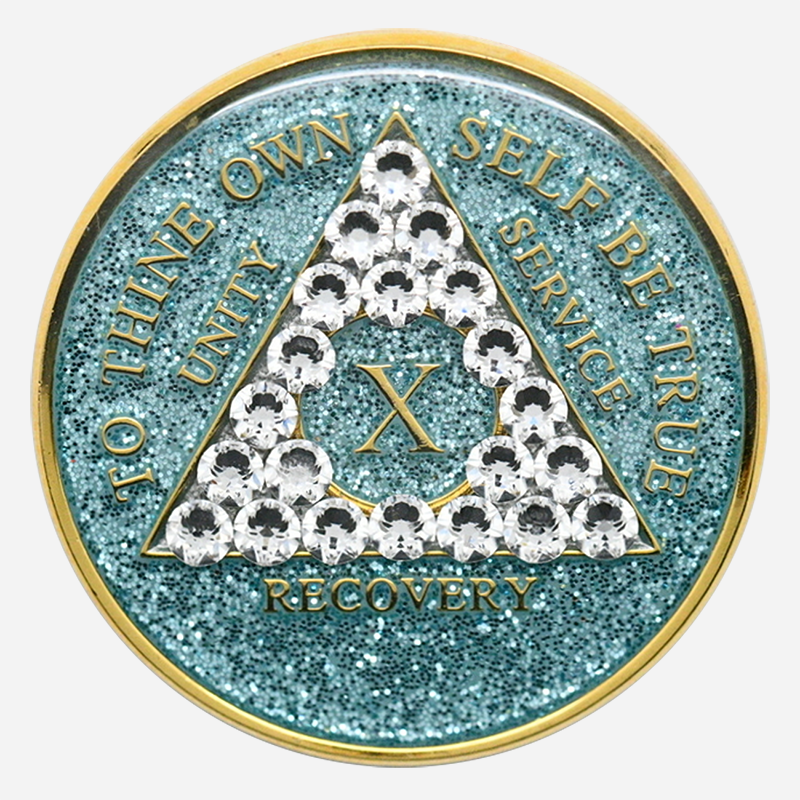 Embrace Renewal with the Crystal AA Medallion Glitter Aqua/Diamond The Crystal AA Medallion Glitter Aqua/Diamond shines as a symbol of growth and resilience on the journey of sobriety. Featuring a serene aqua background with a diamond-clear Swarovski crystal accent, each medallion is handcrafted by individuals in recovery. Available for milestones from 1 to 50 years, this medallion brings together the qualities of clarity, strength, and renewal, making it a powerful reminder of each accomplishment in recovery. Features: Material: With a genuine Swarovski crystal in diamond-clear tones set against a sparkling aqua background, this Glitter Aqua Diamond Crystal AA Medallion radiates peace and focus. Its hand-painted aqua finish is encased in a high-quality, chip-resistant resin dome to ensure lasting brilliance and durability. Front Design: The AA triangle stands proudly on the glittering aqua background, bordered by diamond-clear crystal accents around the phrase “To Thine Own Self Be True,” symbolizing authenticity and self-reflection in recovery. Roman numerals within the triangle commemorate each sobriety year, adding a personal touch that honors each milestone. Back Design: The reverse side features a single diamond-clear Swarovski crystal centered within the engraved Serenity Prayer, offering peace, clarity, and daily encouragement for the journey ahead. Dimensions: This Crystal AA Chip Glitter Aqua/Diamond measures 34mm (1.34 inches) in diameter, designed to be easily carried as a reminder of strength and resilience on the path of recovery. Durability: With a protective, scratch-resistant resin dome, the medallion’s sparkling aqua finish and crystal accents are designed to endure, providing a reliable token that reflects the steady commitment to sobriety. Benefits: Symbolism: The aqua glitter background and diamond-clear crystals represent renewal, clarity, and peace. This medallion embodies the growth and serenity that sobriety brings, encouraging each person to continue forward with strength and resolve. Personalization: Roman numerals from 1 to 50 years mark each unique milestone, creating a personal connection to each year in recovery and serving as an enduring reminder of dedication and perseverance. Gifting: Arriving in a soft velour pouch, this medallion is a heartfelt gift for anyone celebrating their journey in sobriety. Its thoughtful design supports and inspires each individual, reflecting the strength found through recovery and the beauty of each step forward. Order Your Crystal AA Medallion Glitter Aqua/Diamond Today Celebrate your journey with the Crystal AA Medallion Glitter Aqua/Diamond. Order today to enjoy fast, free shipping on all medallions, ensuring that this special token arrives in time to recognize your achievements or to encourage someone close to you. Complete the Gift with: Key Chain Holders Keep your medallion close with one of our premium Key Chain Holders, designed for both style and security on the go. Sober Greeting Cards Add a personal message of encouragement with one of our Sober Greeting Cards, ideal for celebrating each meaningful milestone. Book Covers with Chip Holders Protect your medallion and recovery literature with one of our elegant Book Covers with Chip Holders, providing accessibility and support throughout your journey.